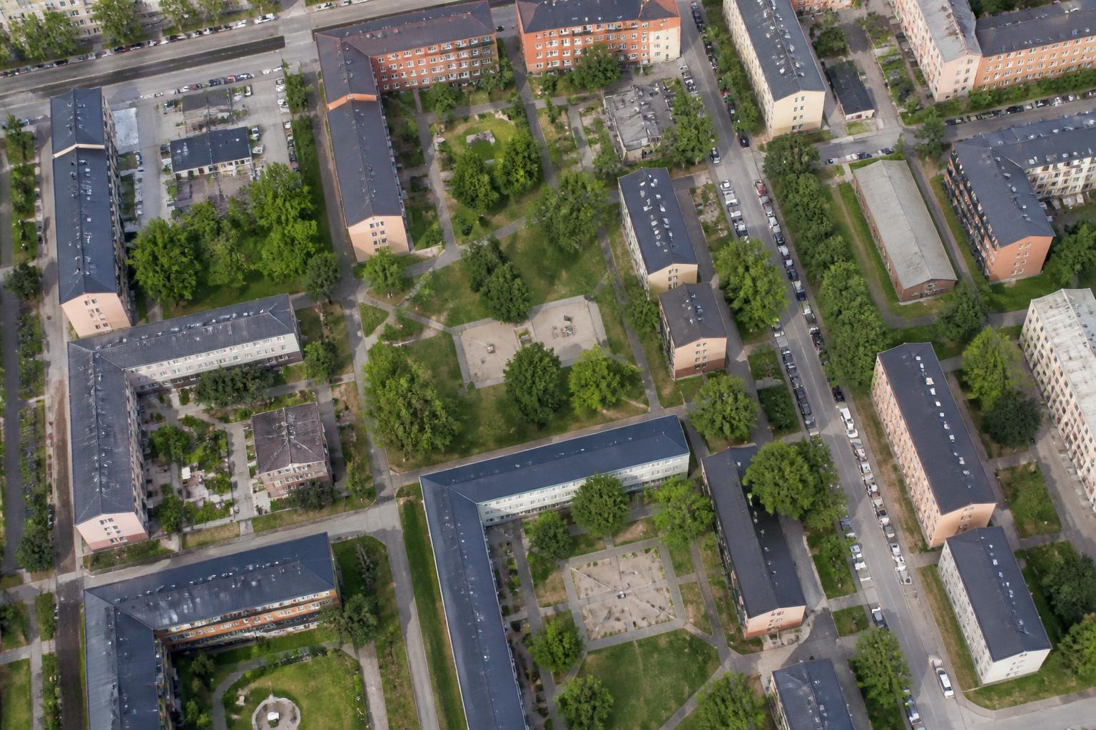 Flygbild över ett bostadsområde med flerfamiljshus och gröna gårdar
